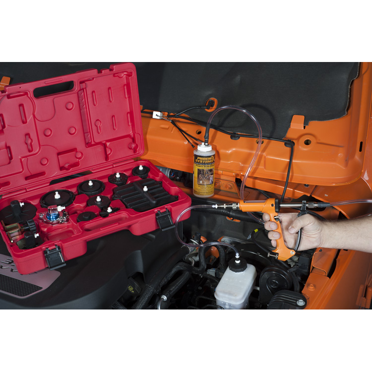The image shows a person using a brake bleeding kit on a vehicle.  Brake bleeding involves forcing fresh brake fluid through the brake system to remove air bubbles, which can compromise the braking performance.  pen_spark
