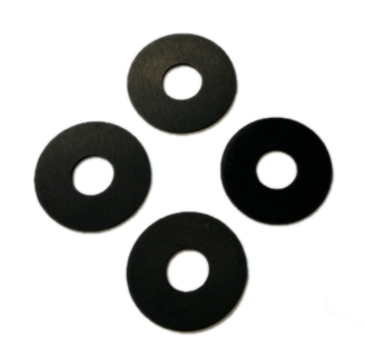 The image depicts four black, ring-shaped objects with a cross-shaped indentation in the center. The objects are laying flat on a light gray, textured surface.  They are commonly referred to as plunger washers.