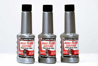The image shows three identical bottles of ESPO brake fluid additive sitting on a table. The text on the label says that the additive is compatible with DOT 3 and DOT 4 brake fluid, and that it extends fluid life, protects brake parts, and safeguards crash avoidance systems. The text also says that the product is made in the USA.
