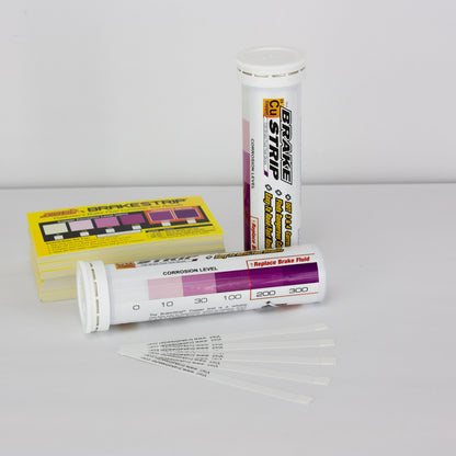 The image shows two containers of Phoenix Systems Brake Fluid Test Strips.  One container is a tube and the other is a box.  Text on the containers describes the product and its function. There is also a chart that appears to indicate a range of corrosion levels.
