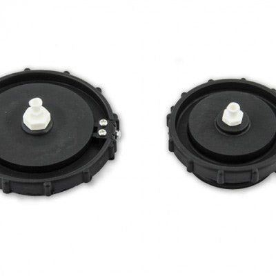 On a white background, the image seems to depict two black plastic cylinder caps with white fitting rings. These caps can be a component of a Honda Master Cylinder Cover Kit.