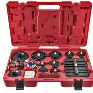 The image depicts a red toolbox containing various adapters and caps, designed for use with a hydraulic bleeder to address brake master cylinder bleeding issues. The text specifies the kit includes universal adapters, manufacturer-specific caps, and an adapter for traditional pressure bleeders, all stored in a custom molded case, and fitting most current master cylinder reservoirs.